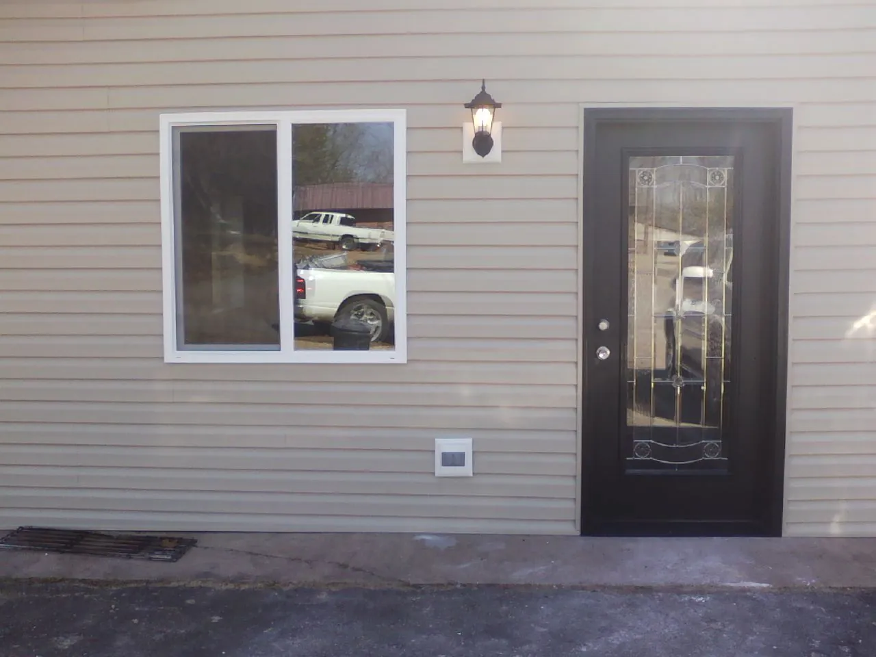 New siding, window and entry door on the side of an addition in Nesmith